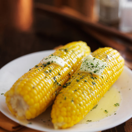 Two ears of corn with garlic herb butter